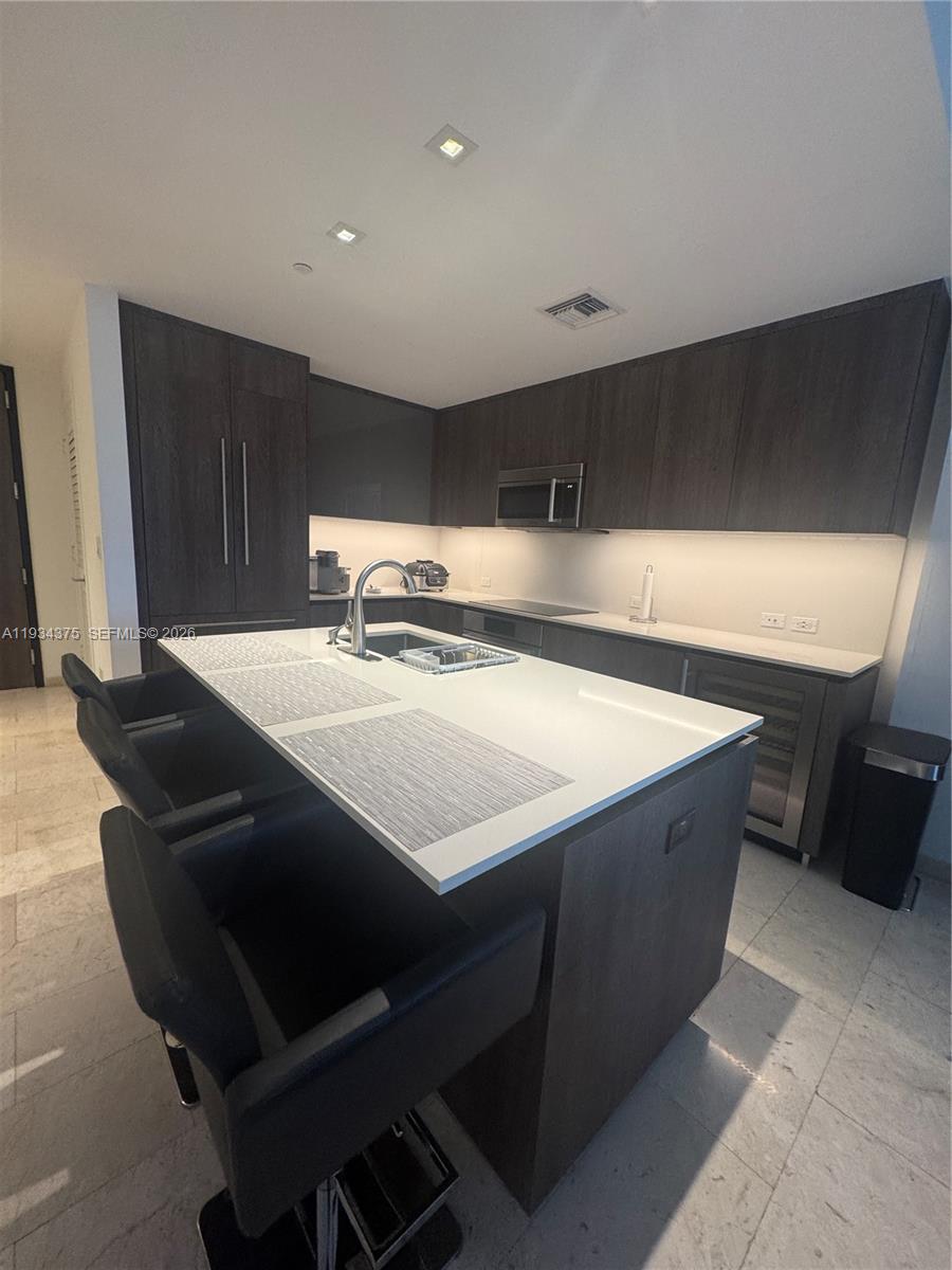 88 Southwest 7th Street, Unit 805 Miami, FL 33130 - Photo 10 of 14 a kitchen with a sink cabinets and wooden floor