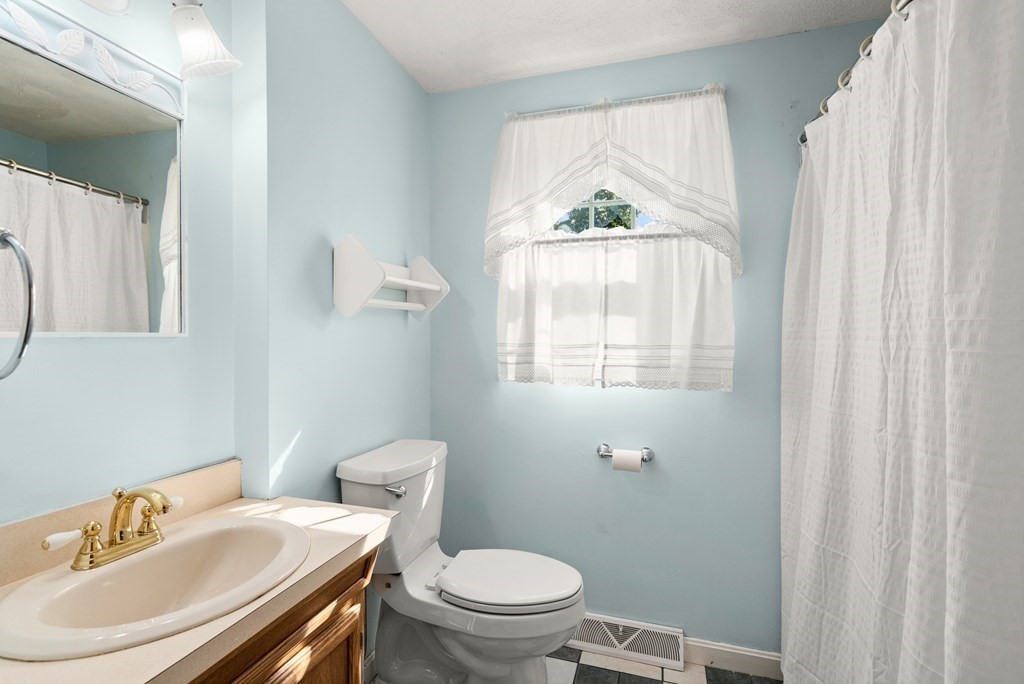 179 Baldwin Road Billerica, MA 01821 - Photo 13 of 38 a bathroom with a sink a toilet and a window