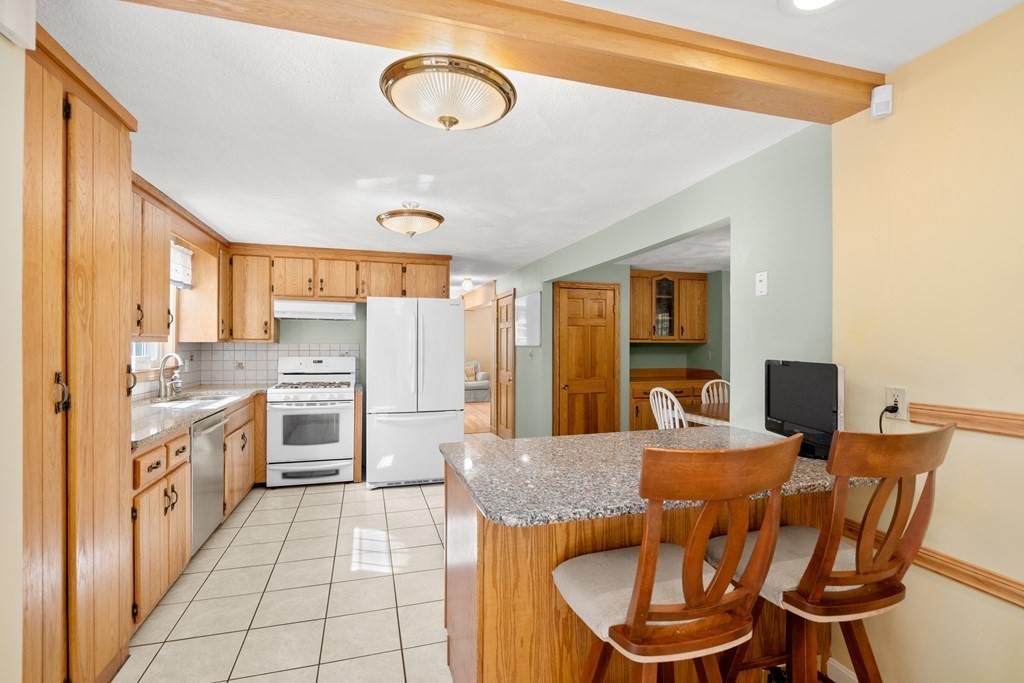 179 Baldwin Road Billerica, MA 01821 - Photo 5 of 38 a kitchen with stainless steel appliances kitchen island granite countertop a table chairs and a refrigerator