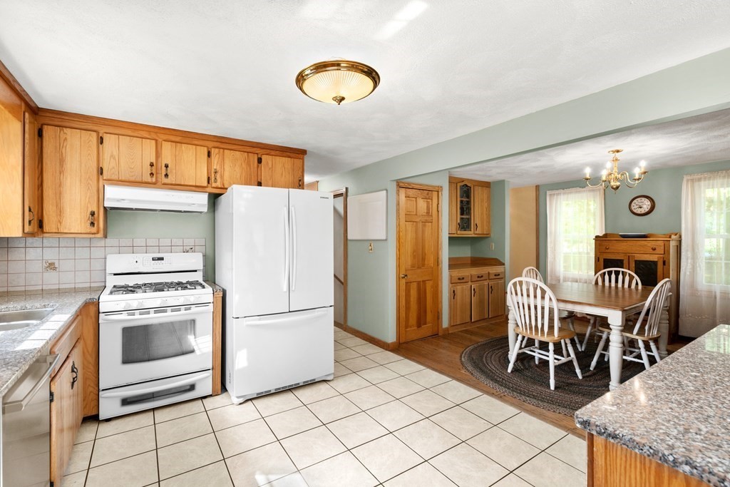 179 Baldwin Road Billerica, MA 01821 - Photo 7 of 38 a kitchen with stainless steel appliances granite countertop a table chairs and a refrigerator