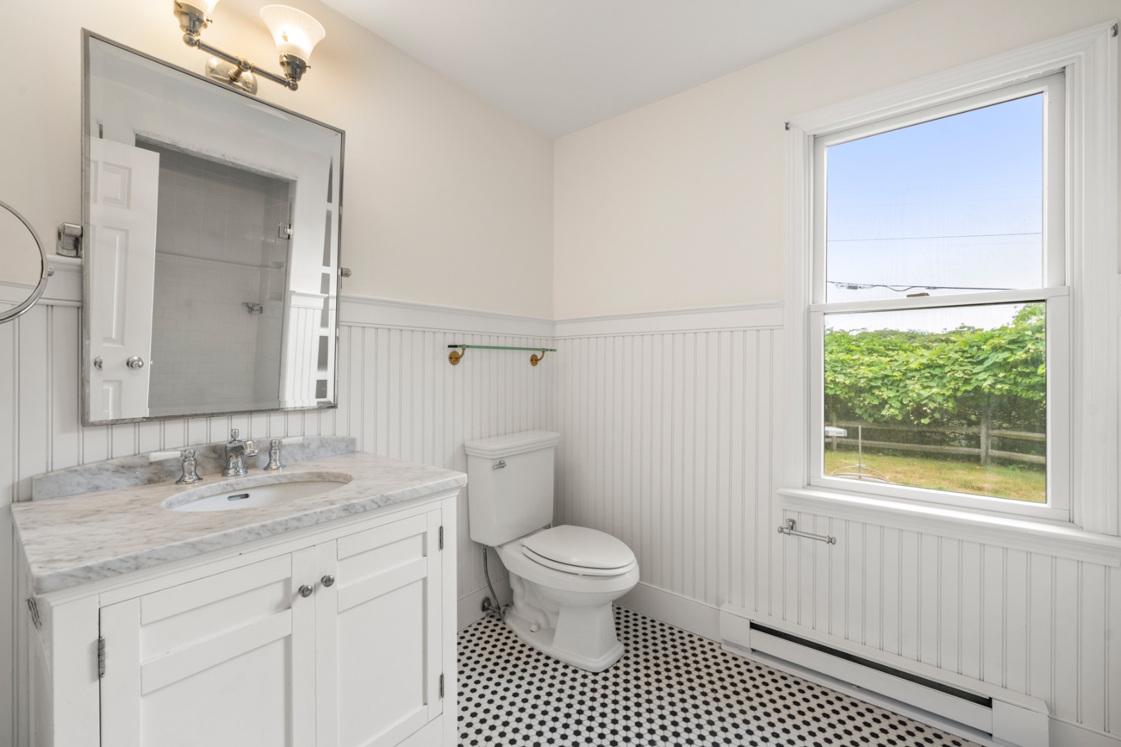 4 Berkley Street Nantucket, MA 02554 - Photo 33 of 47 a bathroom with a granite countertop toilet a sink a mirror a window and a shower