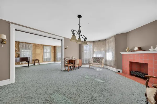 a view of a livingroom with fireplace and window