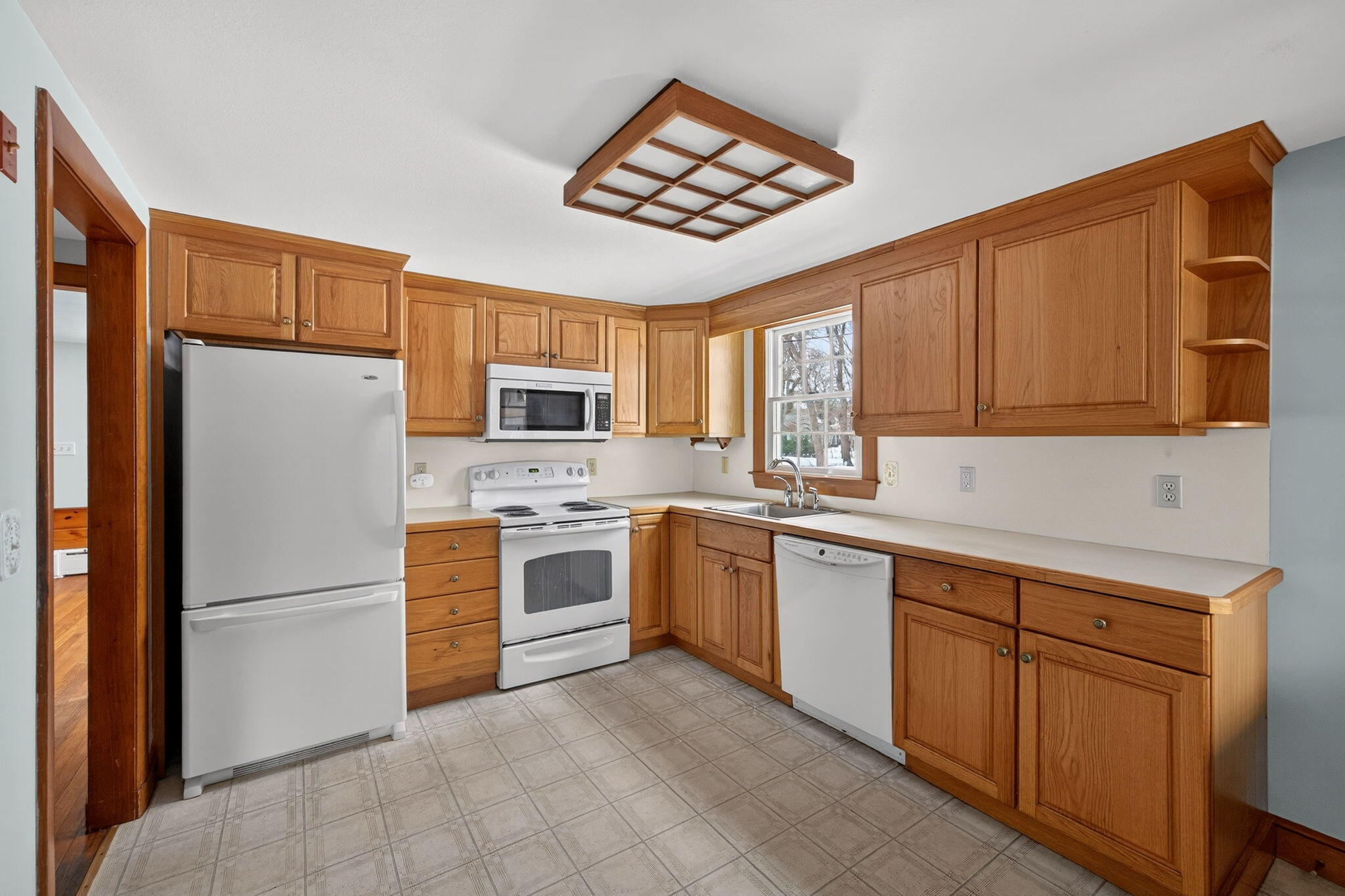 56 Raymond Street Falmouth, MA 02540 - Photo 12 of 45 a kitchen with white cabinets and white appliances