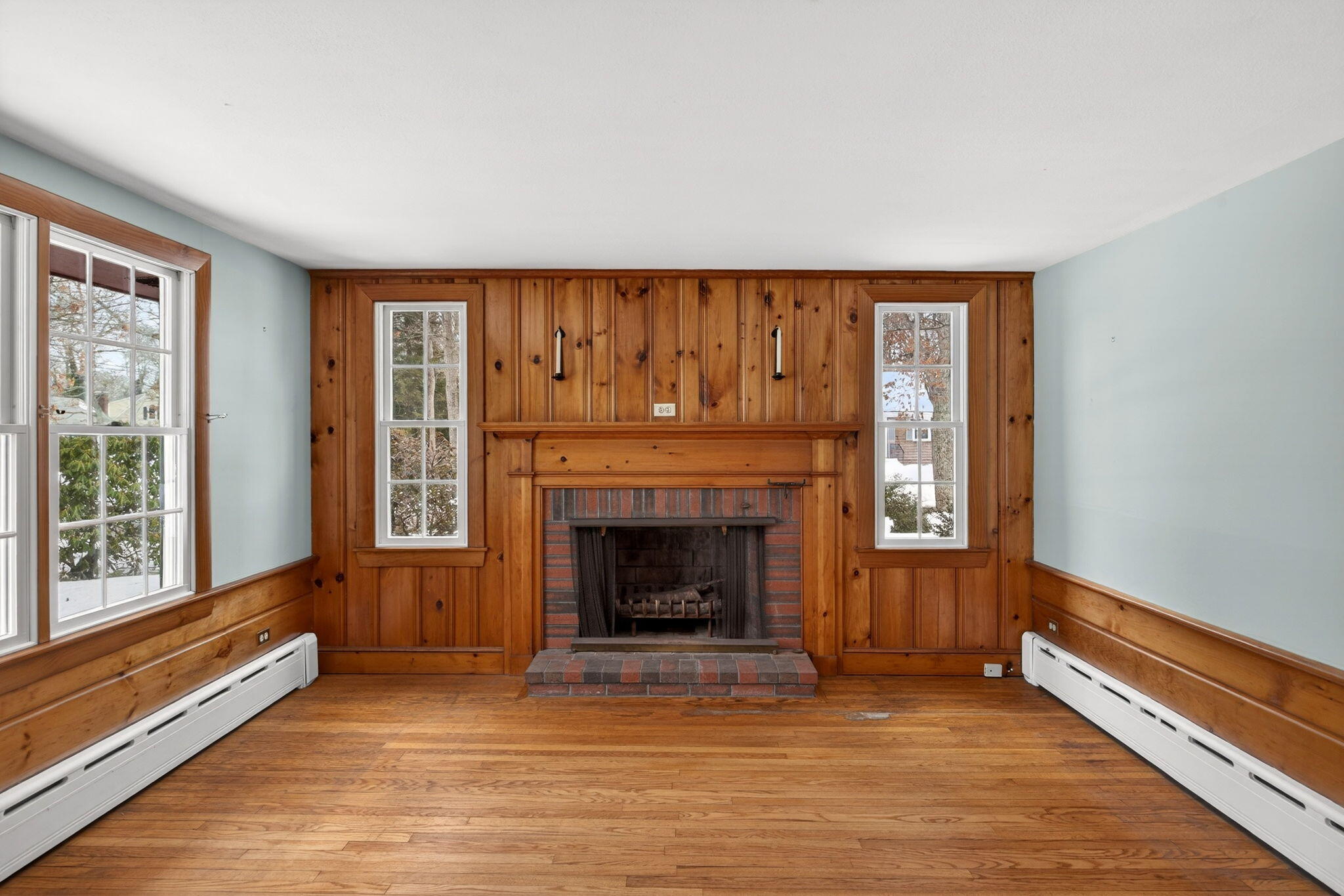 56 Raymond Street Falmouth, MA 02540 - Photo 9 of 45 a view of an empty room with exposed radiator and fireplace