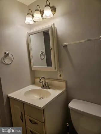 a bathroom with a toilet sink and mirror
