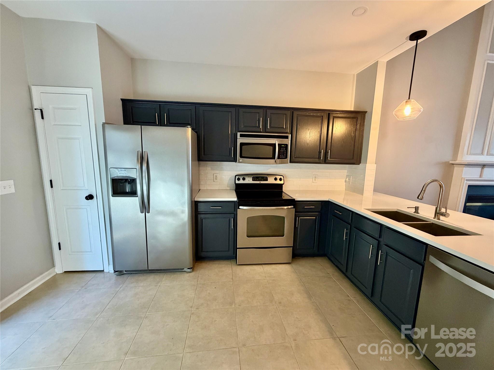 a kitchen with stainless steel appliances granite countertop a refrigerator and a sink