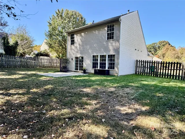 a view of a house with backyard and a tree