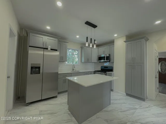 a kitchen with stainless steel appliances granite countertop a refrigerator and a sink