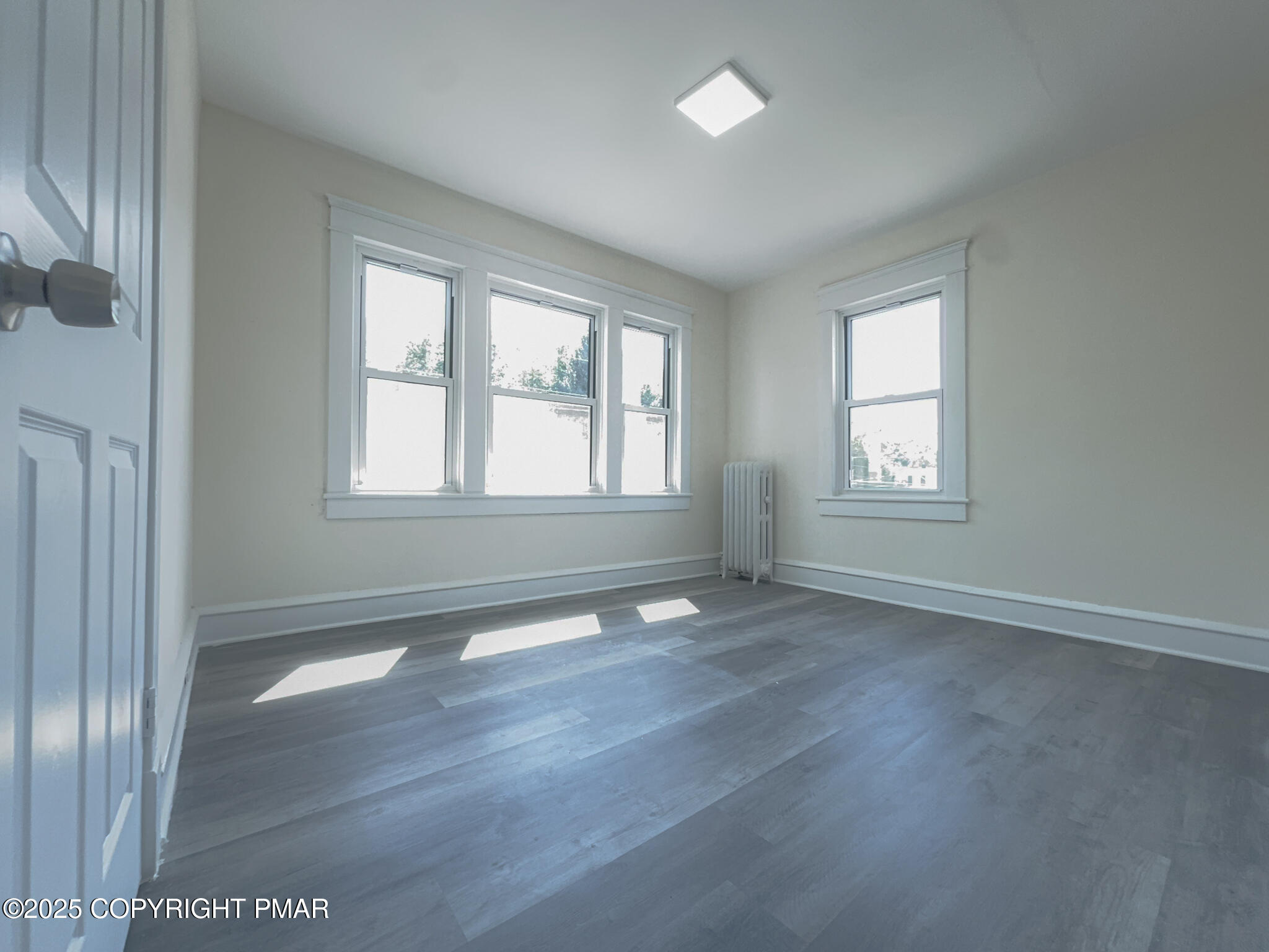 1240 Main Street Pittston, PA 18640 - Photo 17 of 24 an empty room with wooden floor and windows