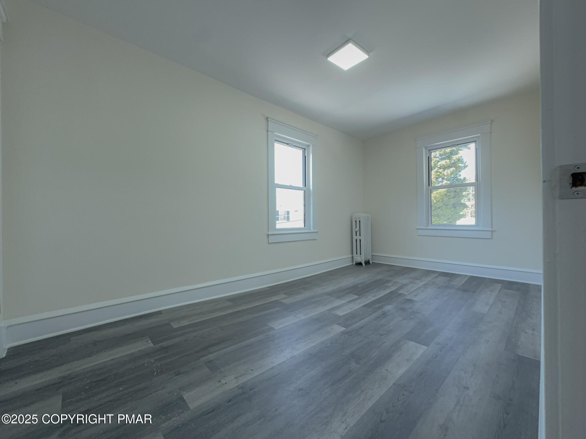 1240 Main Street Pittston, PA 18640 - Photo 18 of 24 an empty room with wooden floor and windows