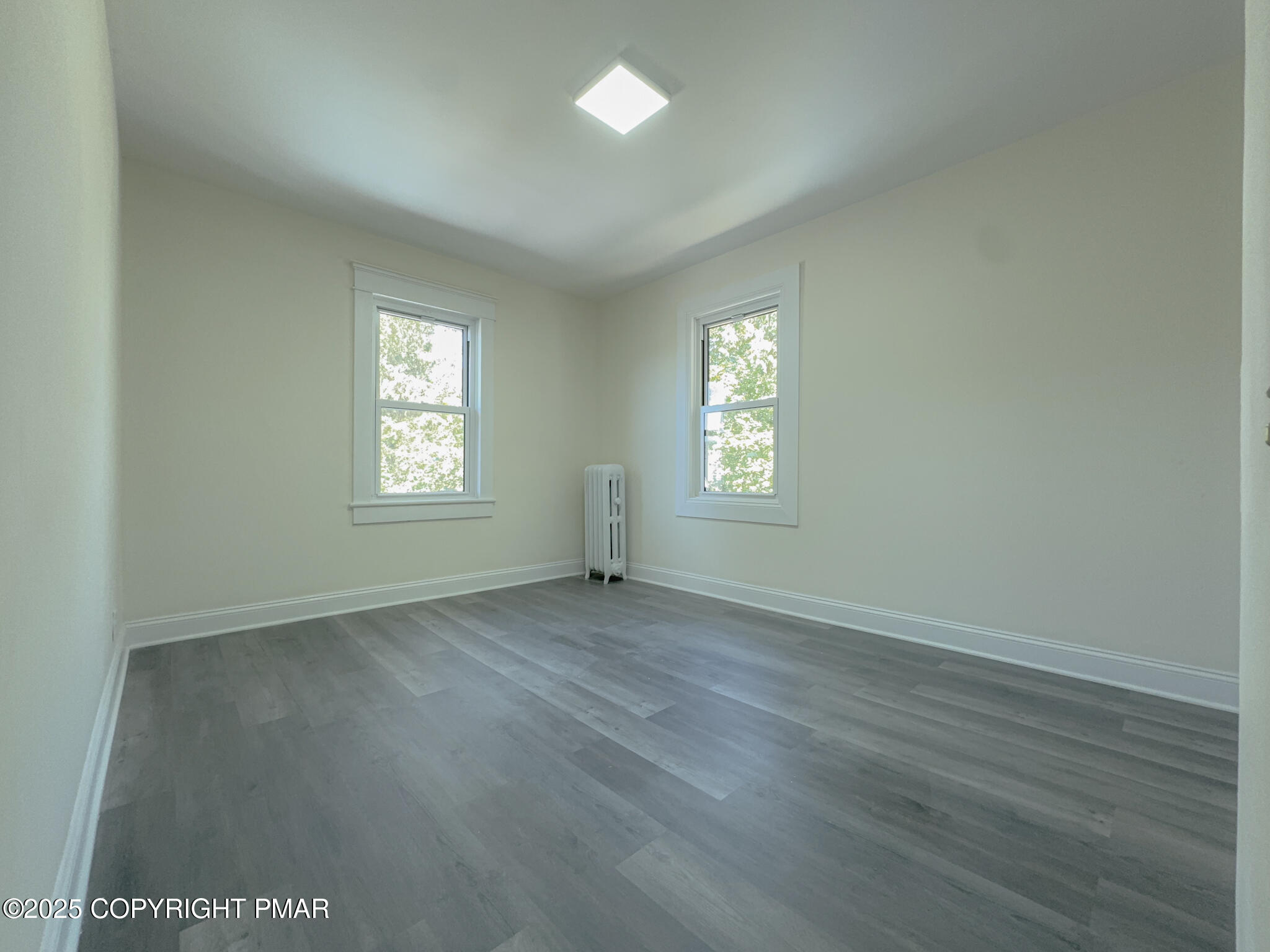 1240 Main Street Pittston, PA 18640 - Photo 19 of 24 an empty room with wooden floor and windows