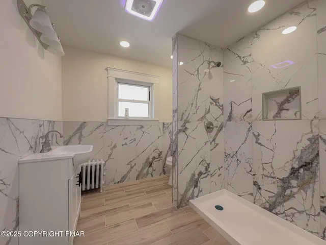 a bathroom with a sink a toilet and shower