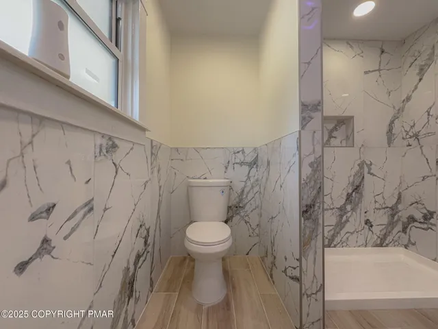 a bathroom with a toilet and a shower