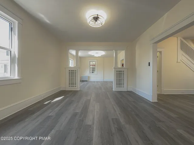a view of a room with wooden floor and a window