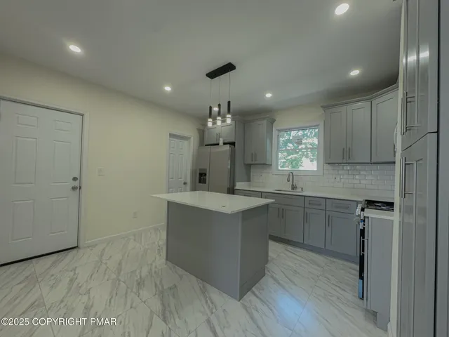 a kitchen with kitchen island a sink stainless steel appliances and cabinets