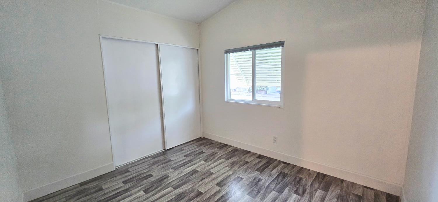 226 Full Circle Davis, CA 95618 - Photo 20 of 27 an empty room with wooden floor and windows