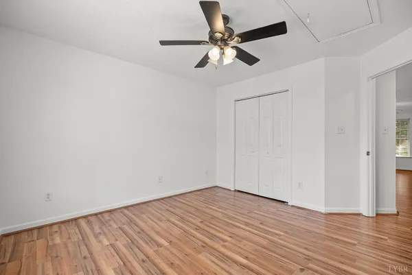 a view of empty room with wooden floor