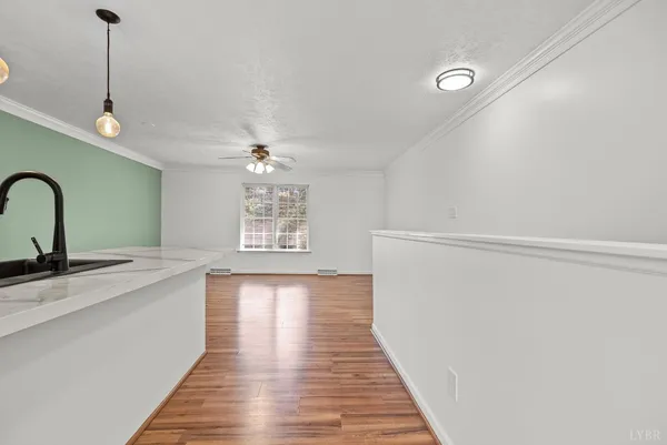a view of a kitchen with a sink wooden floor and a chandelier