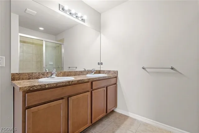 a bathroom with a sink mirror and shower