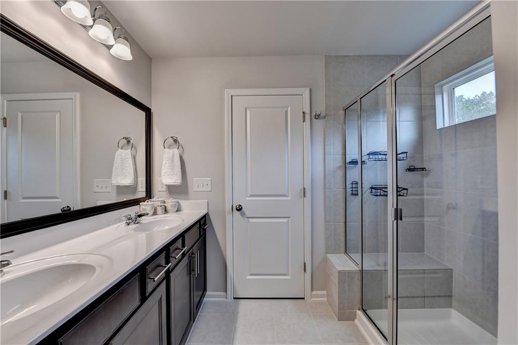 3153 Lowell Road Bethlehem, GA 30620 - Photo 12 of 25 a bathroom with a double vanity sink mirror and shower
