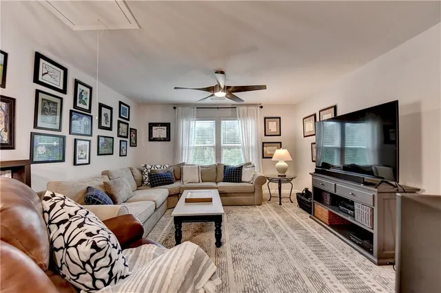 a living room with furniture flat screen tv and a large window