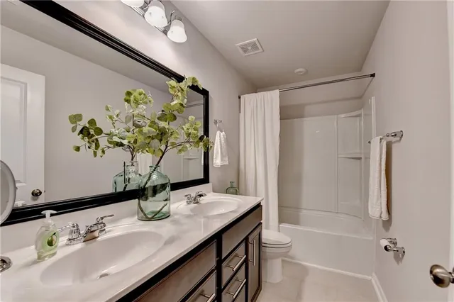 a bathroom with a granite countertop sink a toilet and shower