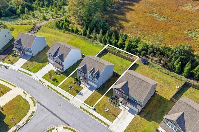 an aerial view of a house with swimming pool and trees