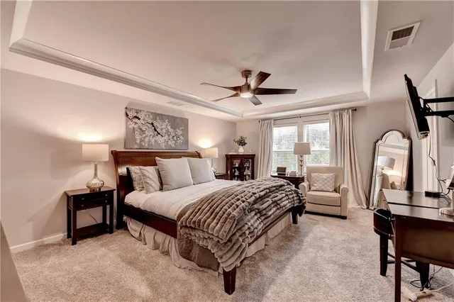 a bedroom with a large bed and a chandelier