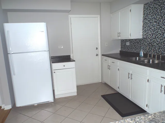 a kitchen with a refrigerator sink and cabinets