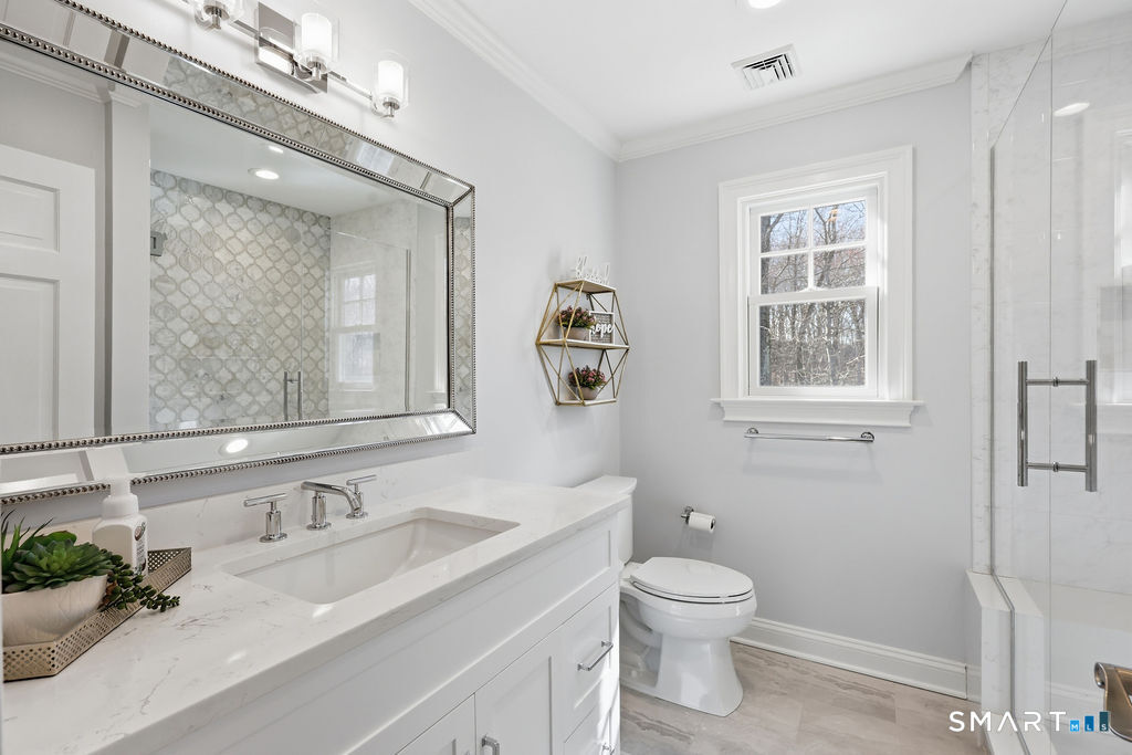 21 Split Rock Road Newtown, CT 06470 - Photo 20 of 40 a bathroom with a granite countertop toilet a sink a mirror and a window