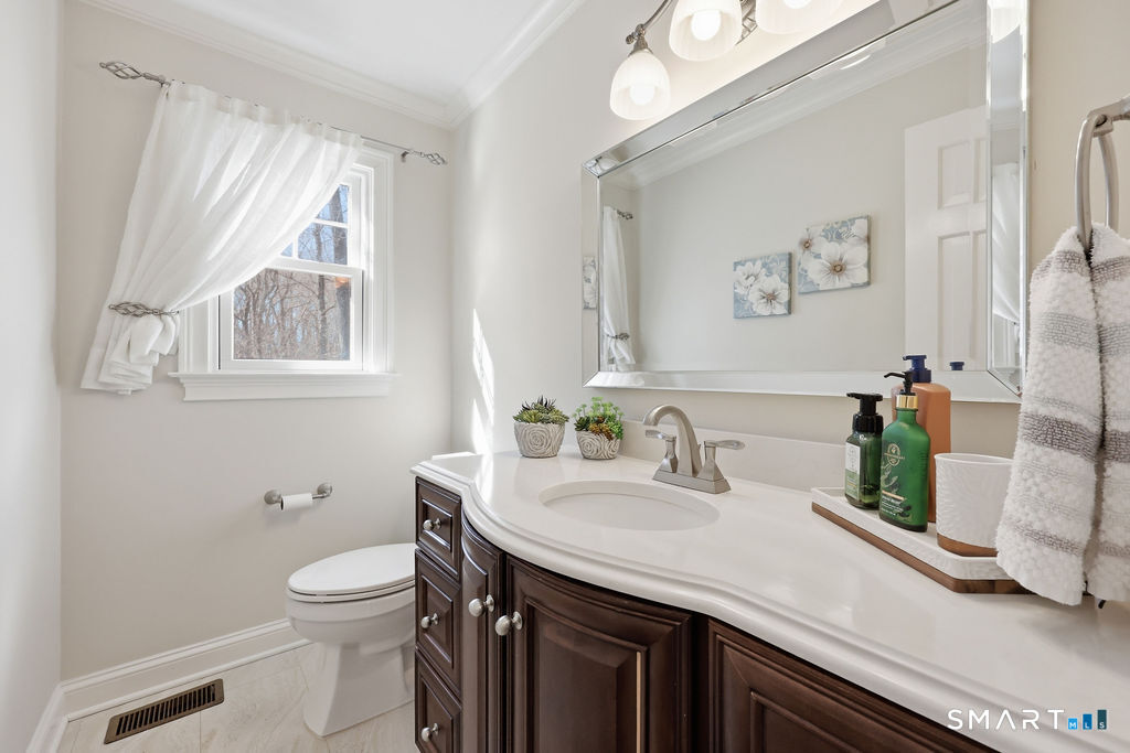 21 Split Rock Road Newtown, CT 06470 - Photo 23 of 40 a bathroom with a granite countertop sink a toilet and a mirror