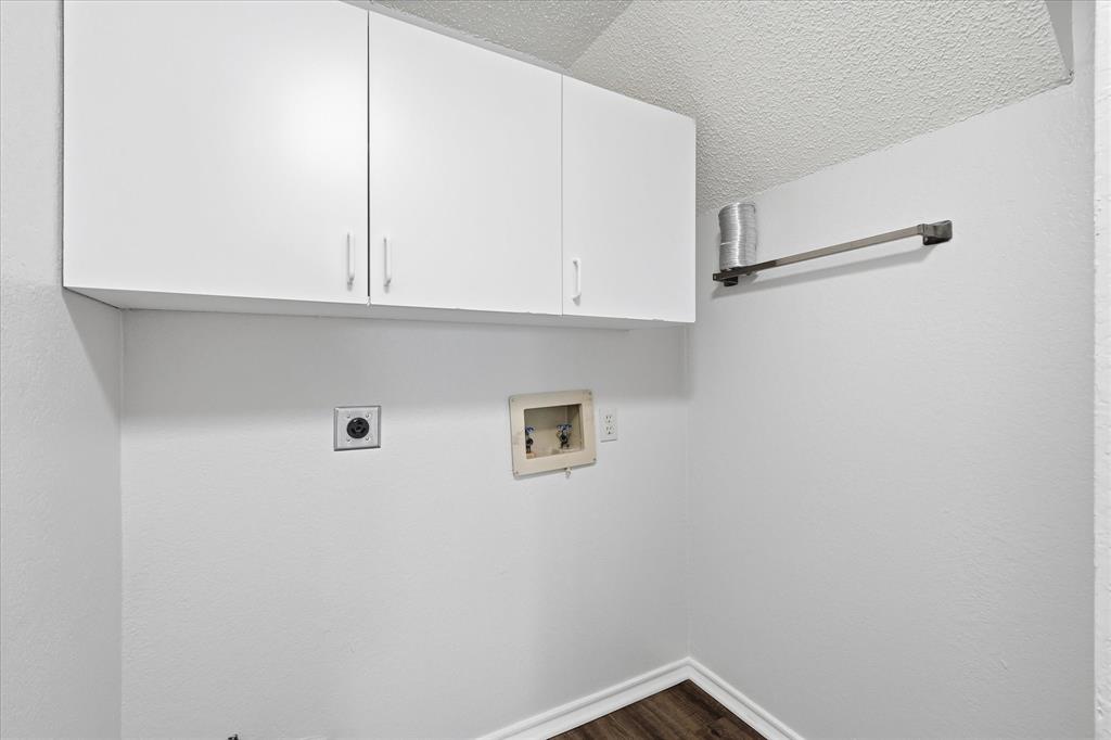318 Lodge Road Coppell, TX 75019 - Photo 11 of 35 A dedicated laundry space with overhead cabinetry keeps everyday essentials neatly organized and within easy reach.