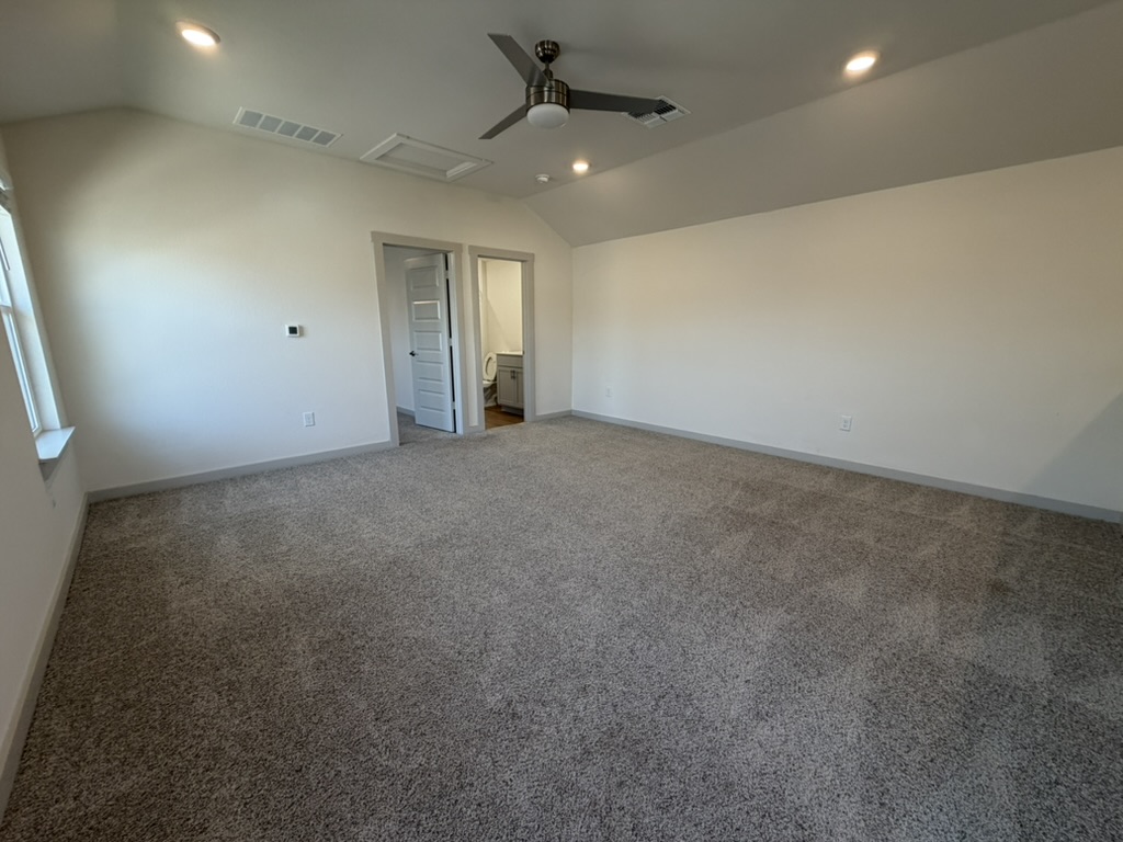 10708 Gonzales Ranger Pass Austin, TX 78754 - Photo 15 of 40 A spacious room features plush carpeting and a modern ceiling fan, offering comfortable living.
