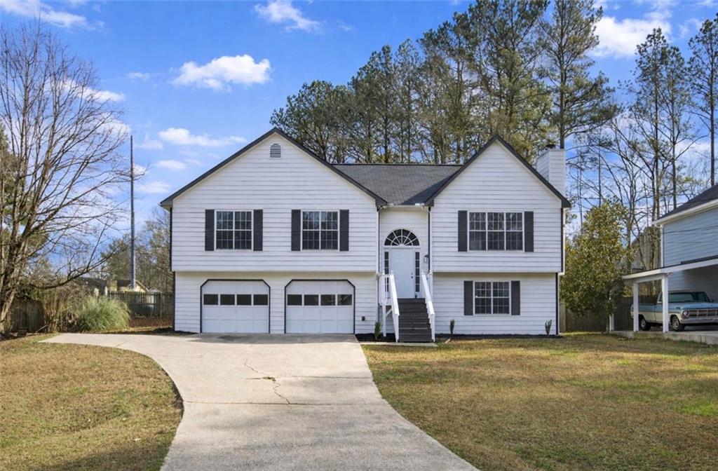 4457 Wesley Way Austell, GA 30106 - Photo 1 of 37 a front view of a house with a yard and garage