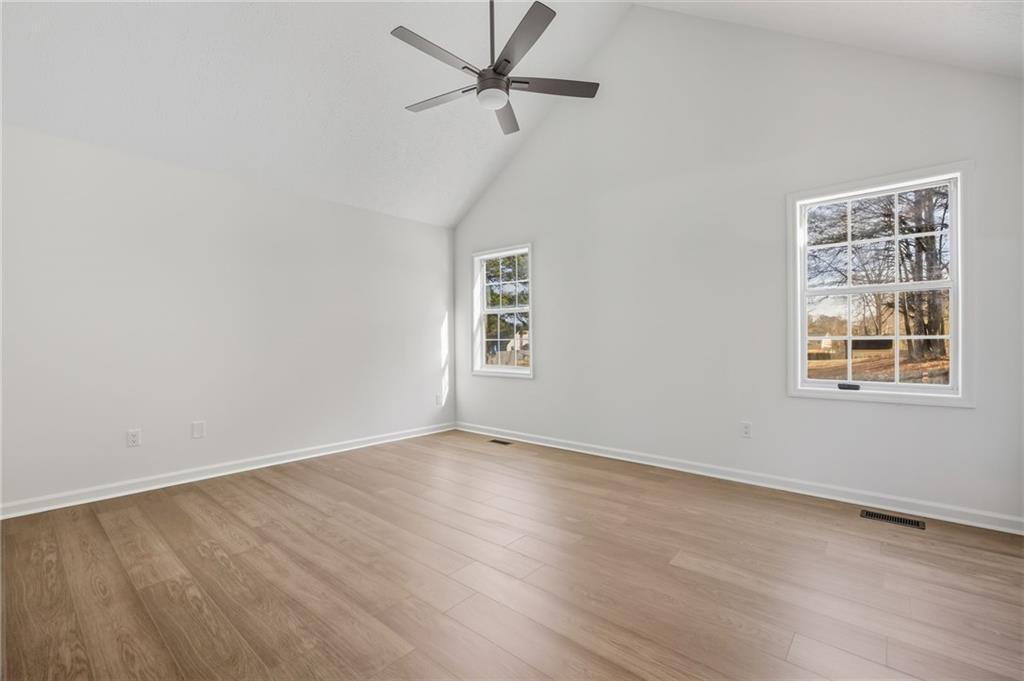 4457 Wesley Way Austell, GA 30106 - Photo 16 of 37 an empty room with wooden floor ceiling fan and windows