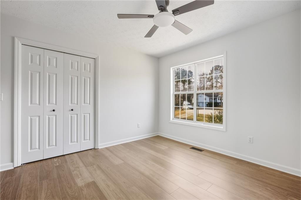 4457 Wesley Way Austell, GA 30106 - Photo 23 of 37 an empty room with wooden floor fan and windows