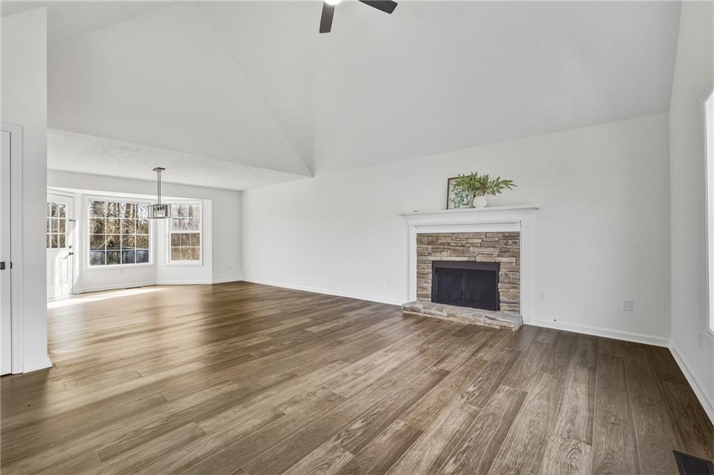 4457 Wesley Way Austell, GA 30106 - Photo 5 of 37 an empty room with wooden floor fireplace and windows
