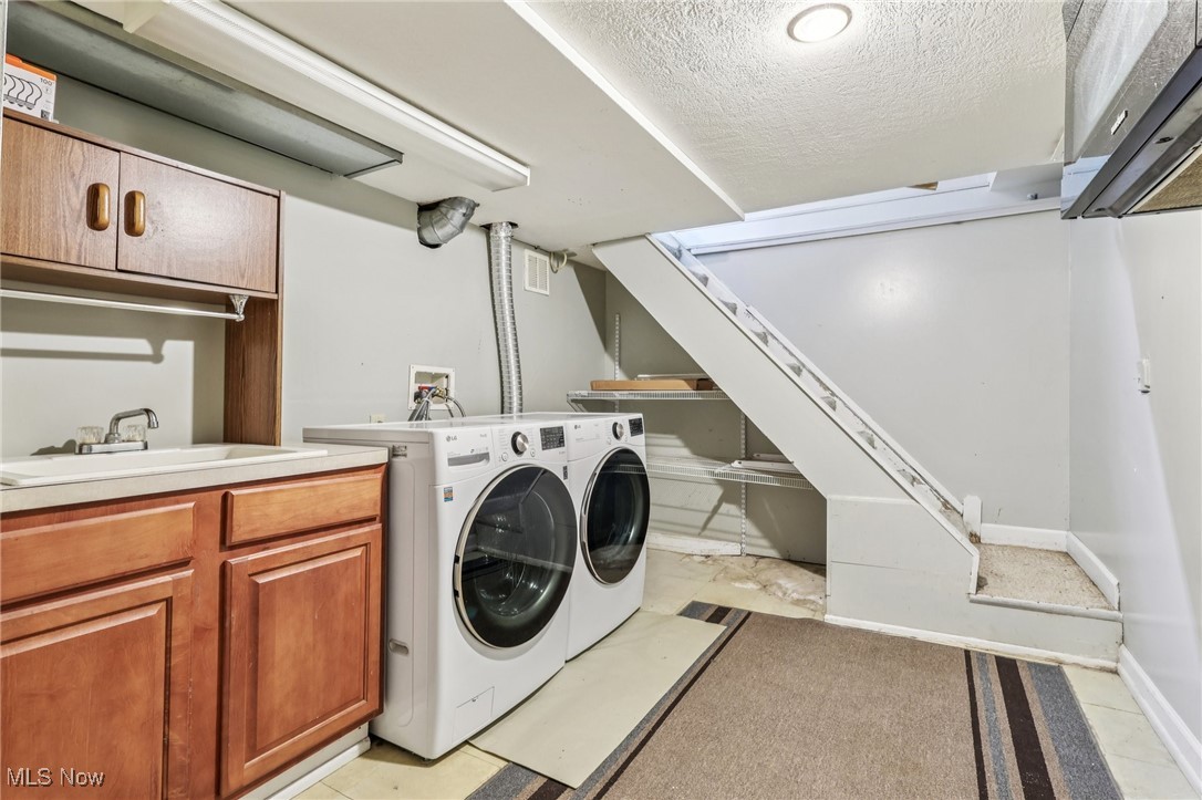 23 Lane Street Rittman, OH 44270 - Photo 12 of 34 Laundry area with cabinet space, a textured ceiling, and washer and clothes dryer