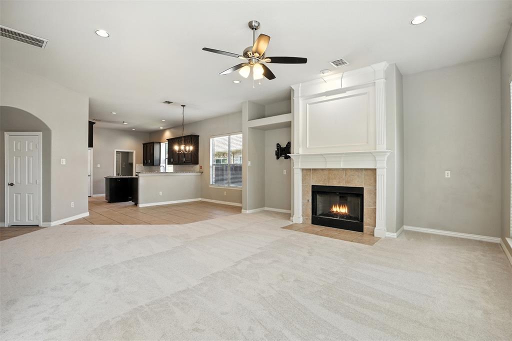 8220 Holliday Road Lantana, TX 76226 - Photo 26 of 40 Living space featuring a prominent fireplace with a detailed white mantel, tile surround, and hearth