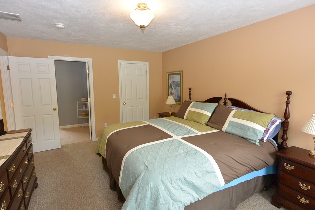 4 Harding Lane Sturbridge, MA 01518 - Photo 12 of 23 a bedroom with a bed and a chandelier