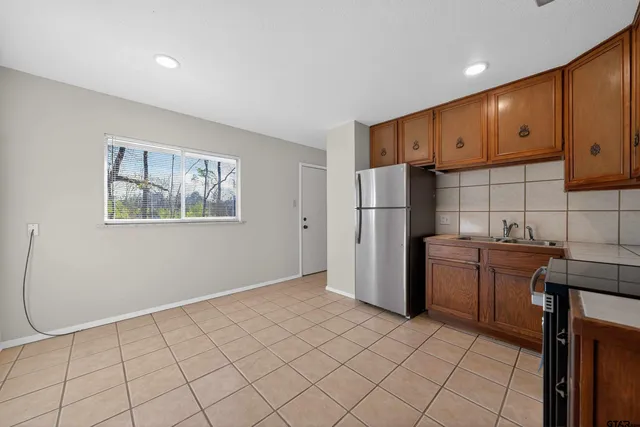 a kitchen with a table chairs refrigerator and cabinets