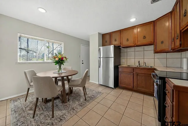 a kitchen with stainless steel appliances granite countertop a refrigerator and a stove top oven