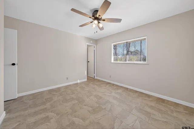 an empty room with a window and a fan