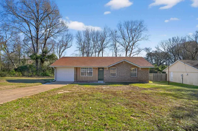 a view of a house with a yard covered with trees