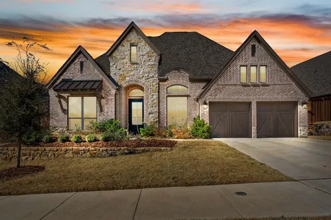 a front view of house with yard and trees in the background