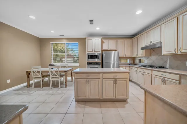 a kitchen with cabinets and chairs