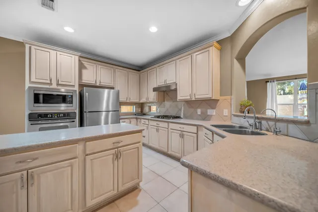 a kitchen with stainless steel appliances granite countertop a refrigerator sink and cabinets