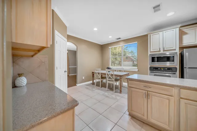 a kitchen with white cabinets and window