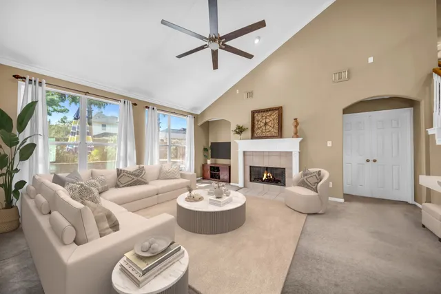 a living room with furniture a fireplace and a large window