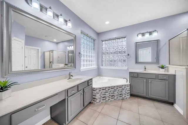 a spacious bathroom with a tub sink and mirror